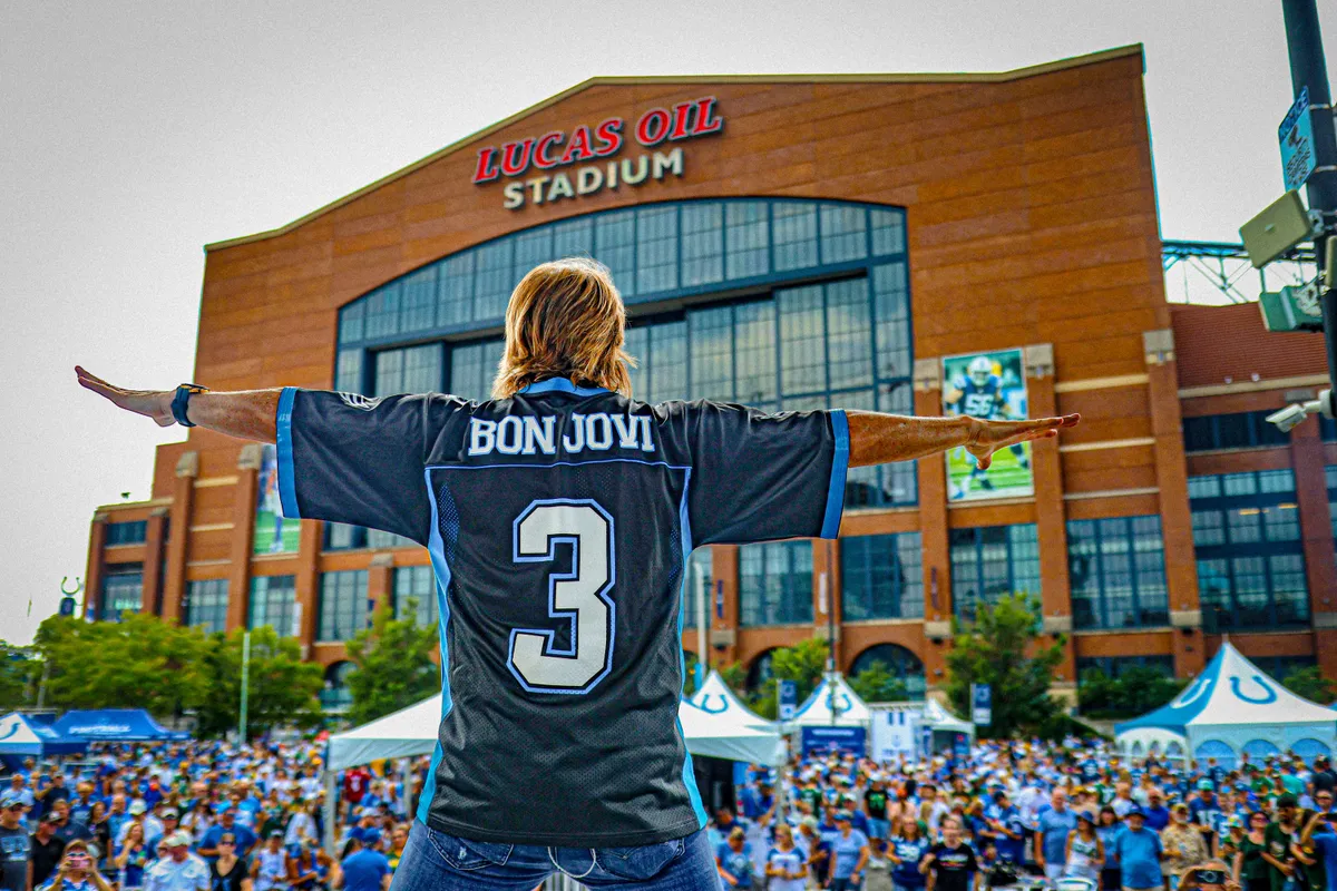 A fan in a Bon Jovi jersey facing the crowd outside Lucas Oil Stadium